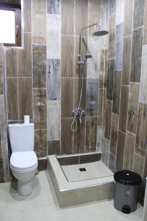 een badkamer met een douche, een toilet en een bad bij Bears and Berries in Berd