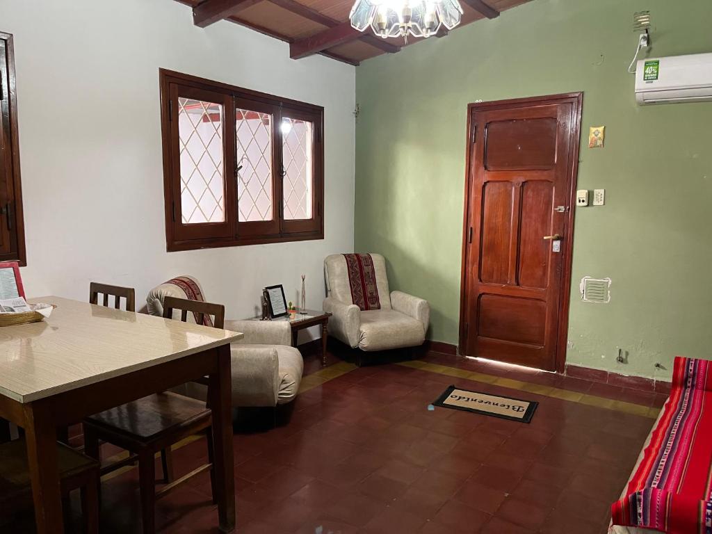 sala de estar con mesa, sillas y puerta en Casa Rústica Norteña Candy Con Parking, en Salta