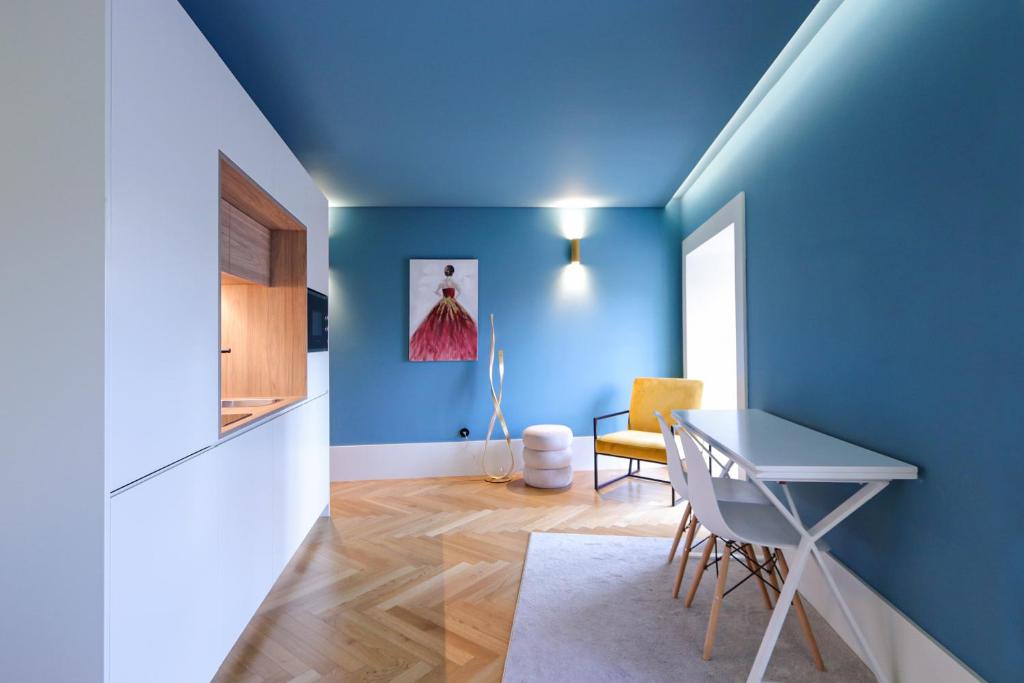 um quarto azul com uma mesa e uma cadeira em HM - Infante Riverside Apartment C no Porto