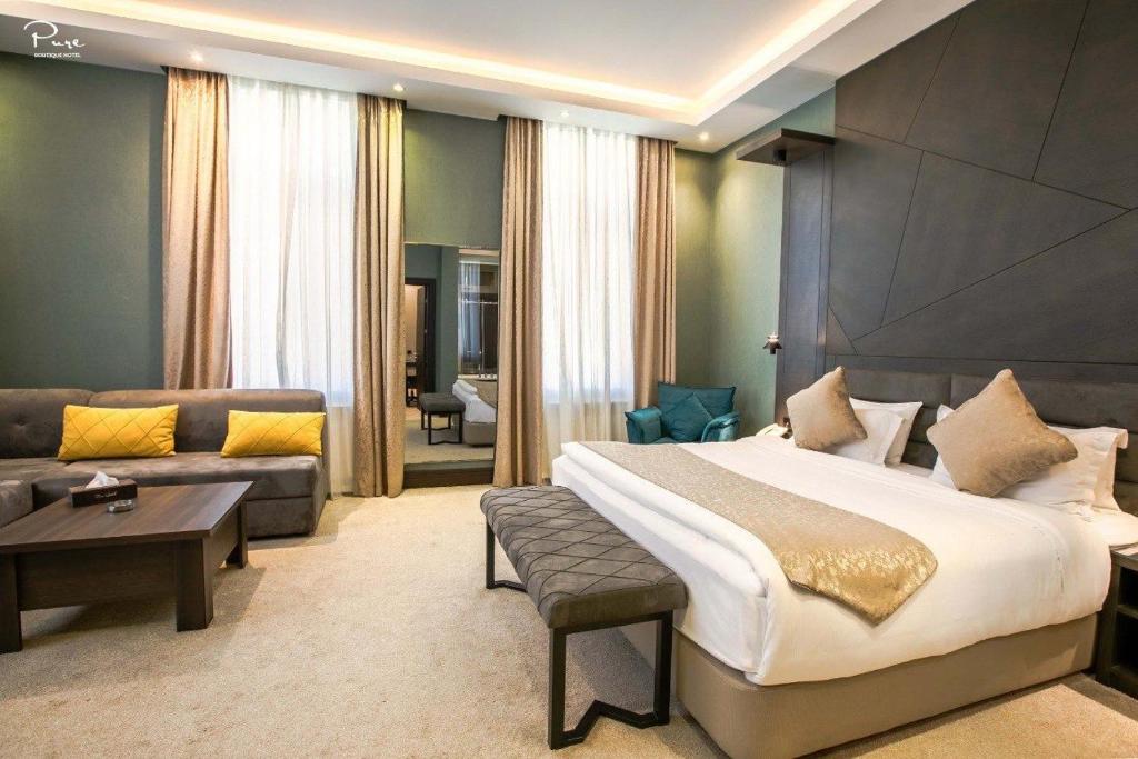 una camera d'albergo con un grande letto e un divano di Pure Boutique Hotel a Baku