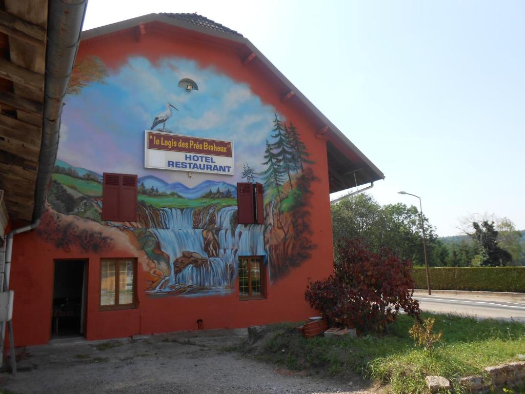 a mural on the side of a red building at Le Logis du Pré Braheux in Saint-Nabord