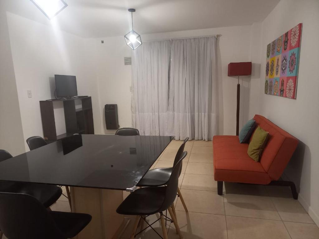 een woonkamer met een tafel en stoelen en een bank bij Apart272 in Río Cuarto