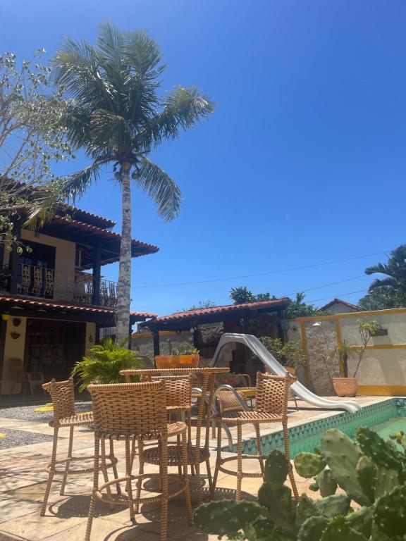 a patio with a table and chairs next to a pool at Suíte com cozinha para casal in Araruama