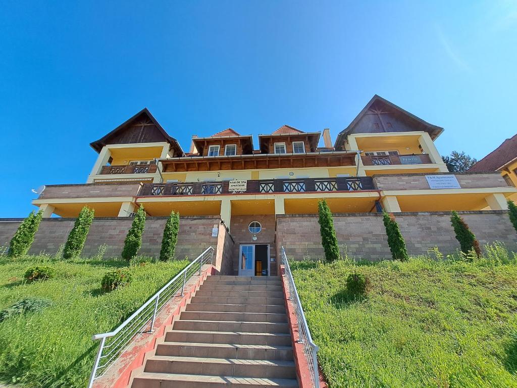 - un bâtiment sur une colline avec des escaliers en face dans l'établissement Forrás Apartman, à Egerszalók