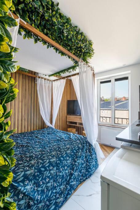 une chambre avec un lit à baldaquin et une fenêtre dans l'établissement Proche Paris - Style Bali 350 m gare Mantes, à Mantes-la-Jolie
