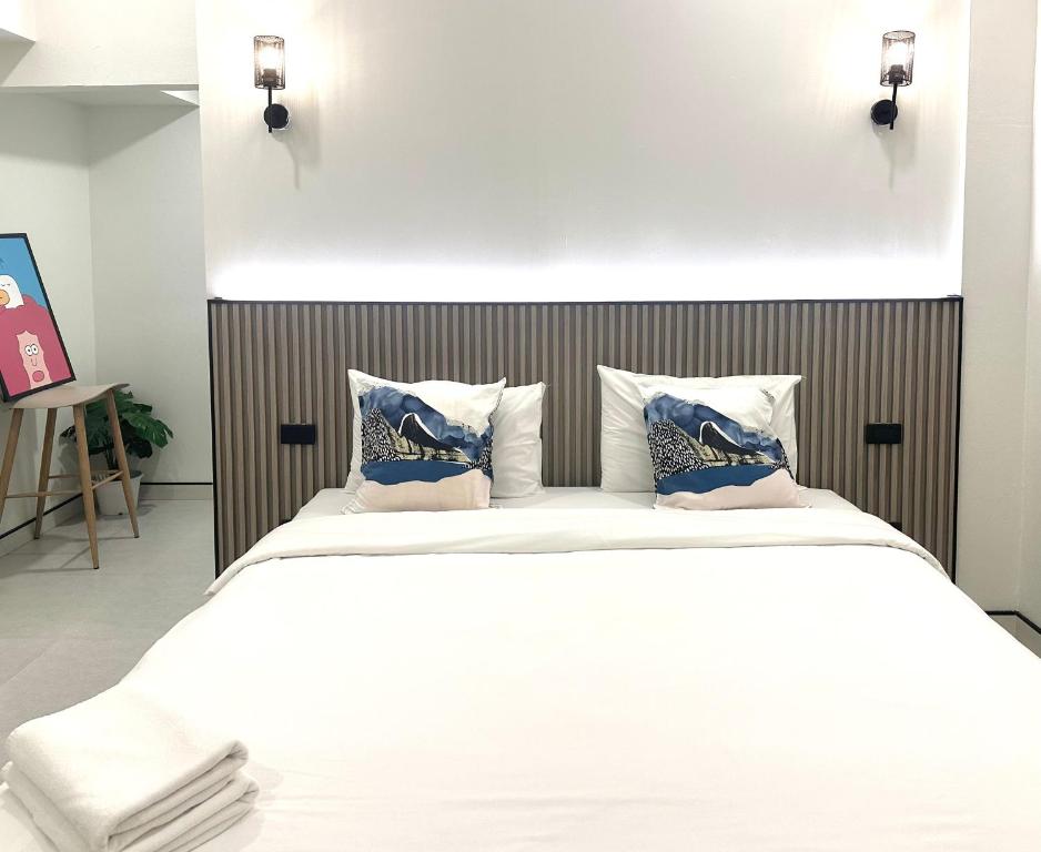 - une chambre avec un grand lit blanc et des oreillers dans l'établissement Now Hostel, à Ban Chang