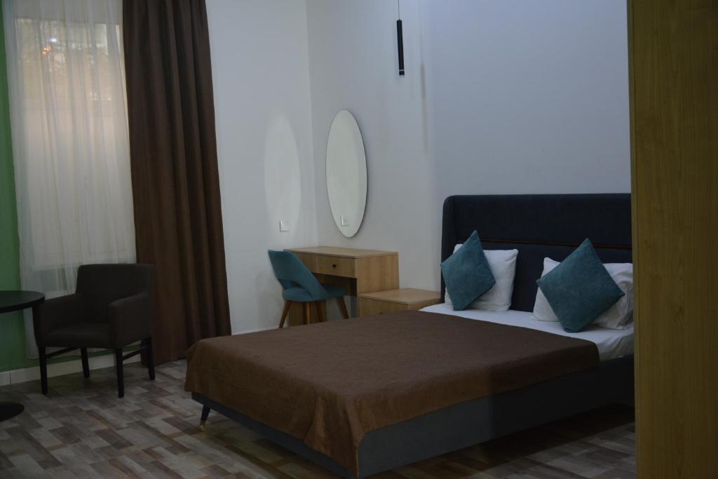 a bedroom with a bed and a table and a chair at Perron Hotel Baku in Baku