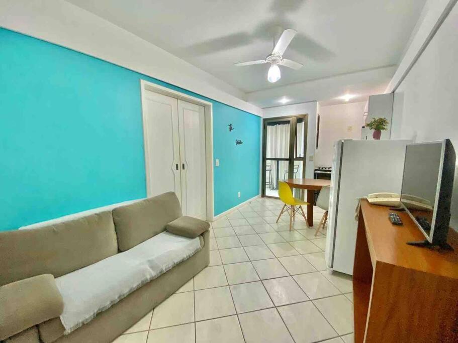 a living room with a couch and a blue wall at Ocean Flat 407 in Vila Velha