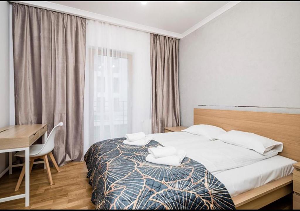Un dormitorio con una cama y un escritorio y una ventana. en GH Luxury Apartment, en Cracovia