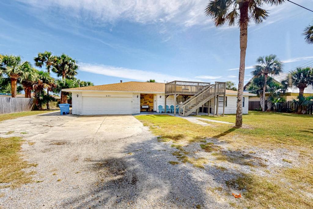 a house with a palm tree in front of it at Beach Life in Panama City Beach