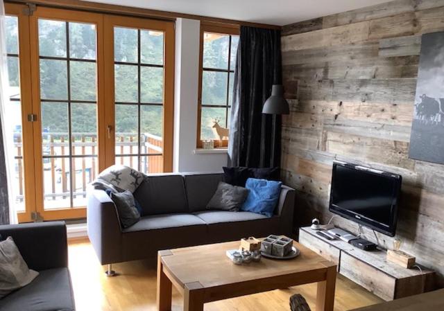 ein Wohnzimmer mit einem Sofa und einem TV in der Unterkunft Steinadler Seekareck FL - Skiing Holiday in Obertauern in Obertauern