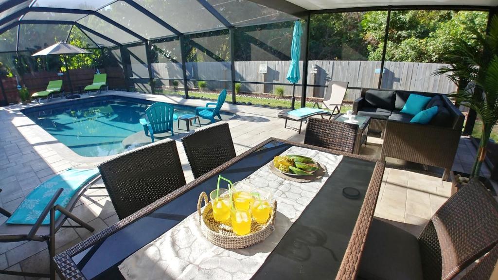a patio with a table and chairs next to a pool at Villa Happy Gator in Venice