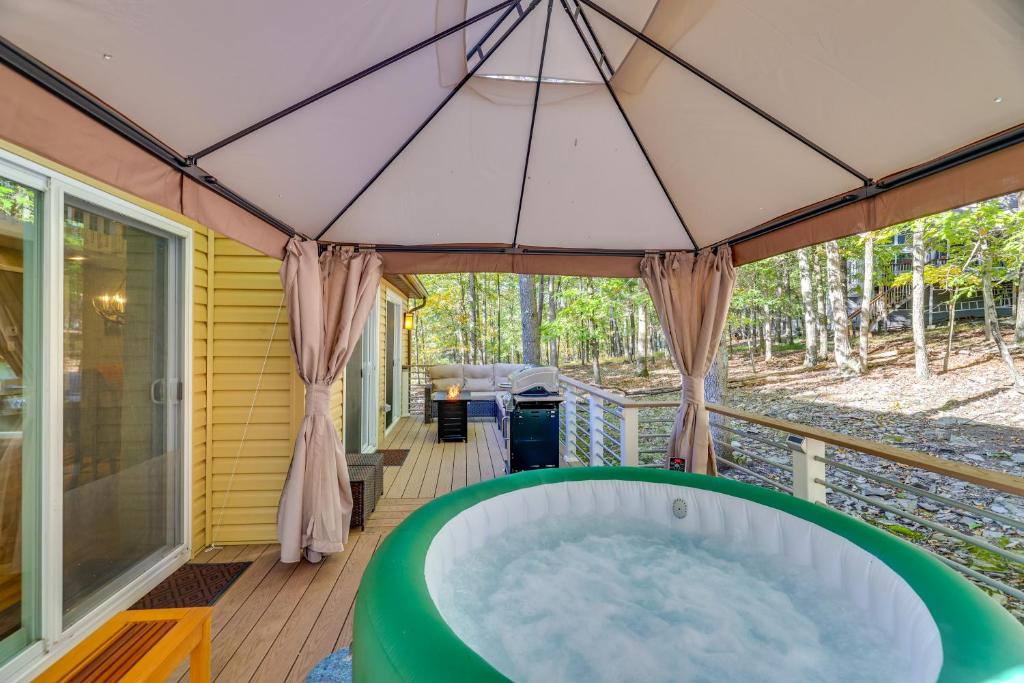 bañera de hidromasaje en la cubierta de una casa en Forest-View Poconos Cabin with Hot Tub!, en East Stroudsburg