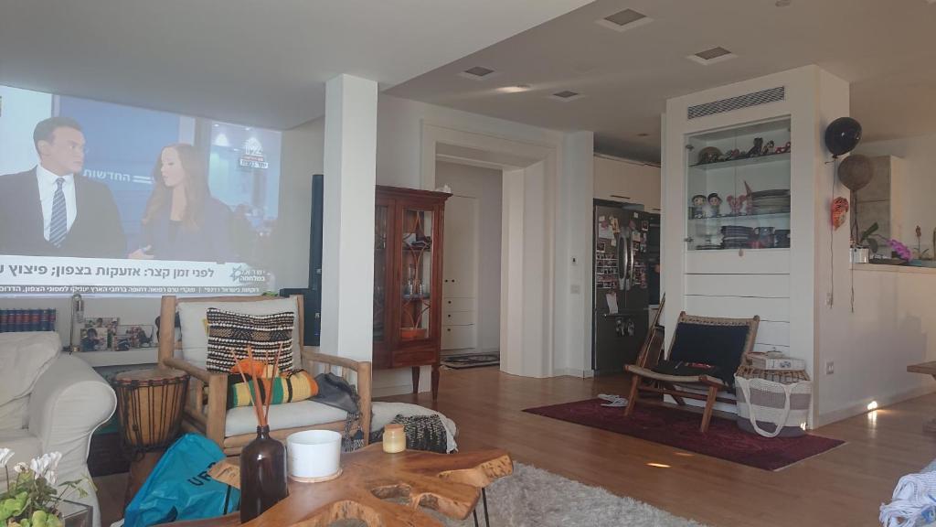 a living room with a couch and a table at שרון על המים in Herzliyya B