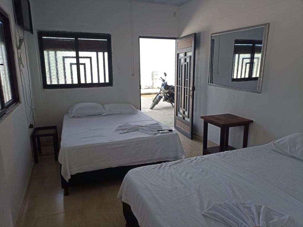a bedroom with two beds and a motorcycle in the window at Alojamiento la esmeralda in Puerto Triunfo