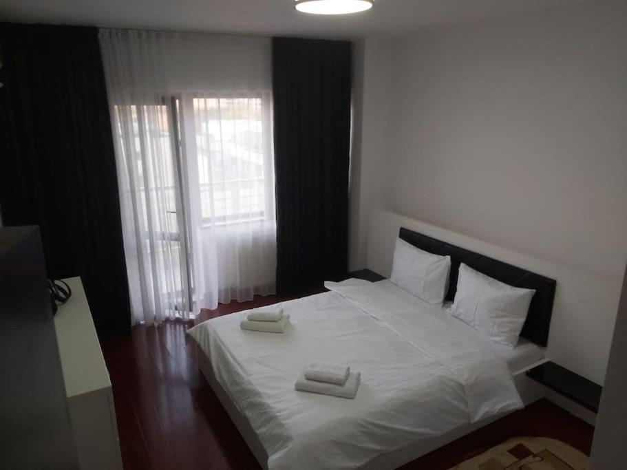 1 dormitorio con 1 cama blanca y 2 toallas en Apartament Complex en Bucarest