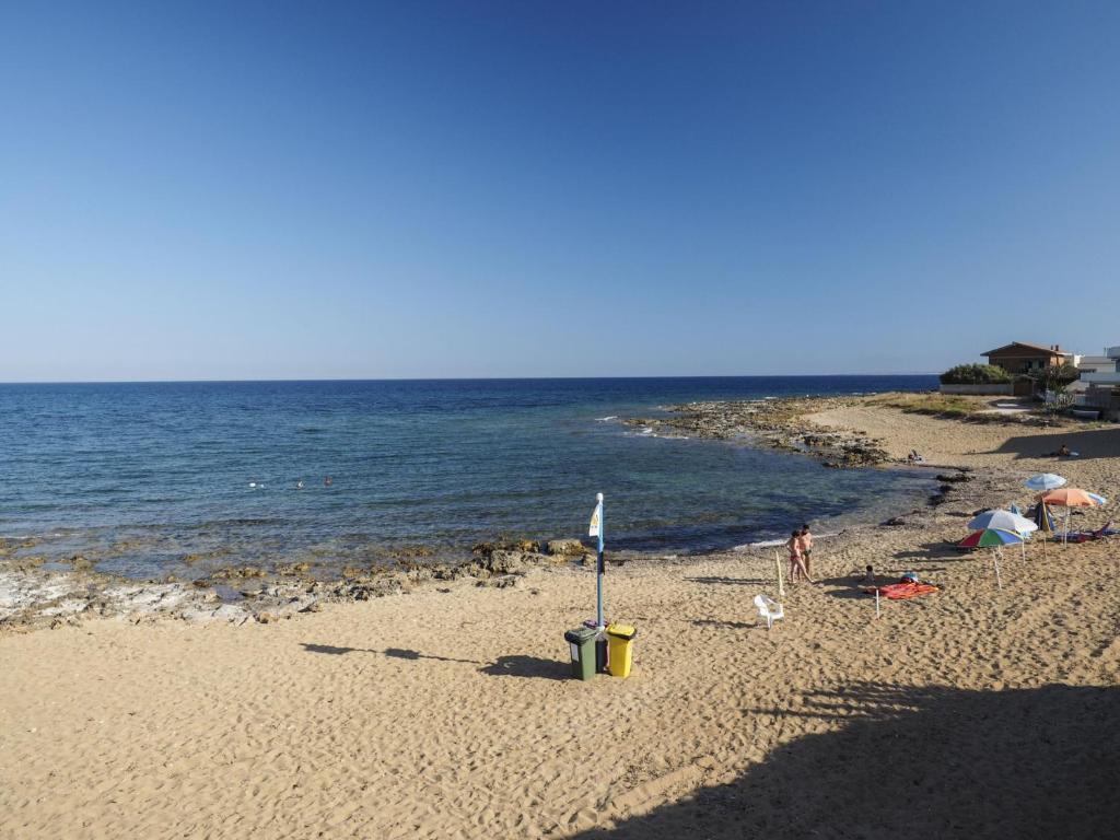 una spiaggia con persone sulla sabbia e sull'acqua di Rifugio a Mare a Calabernardo