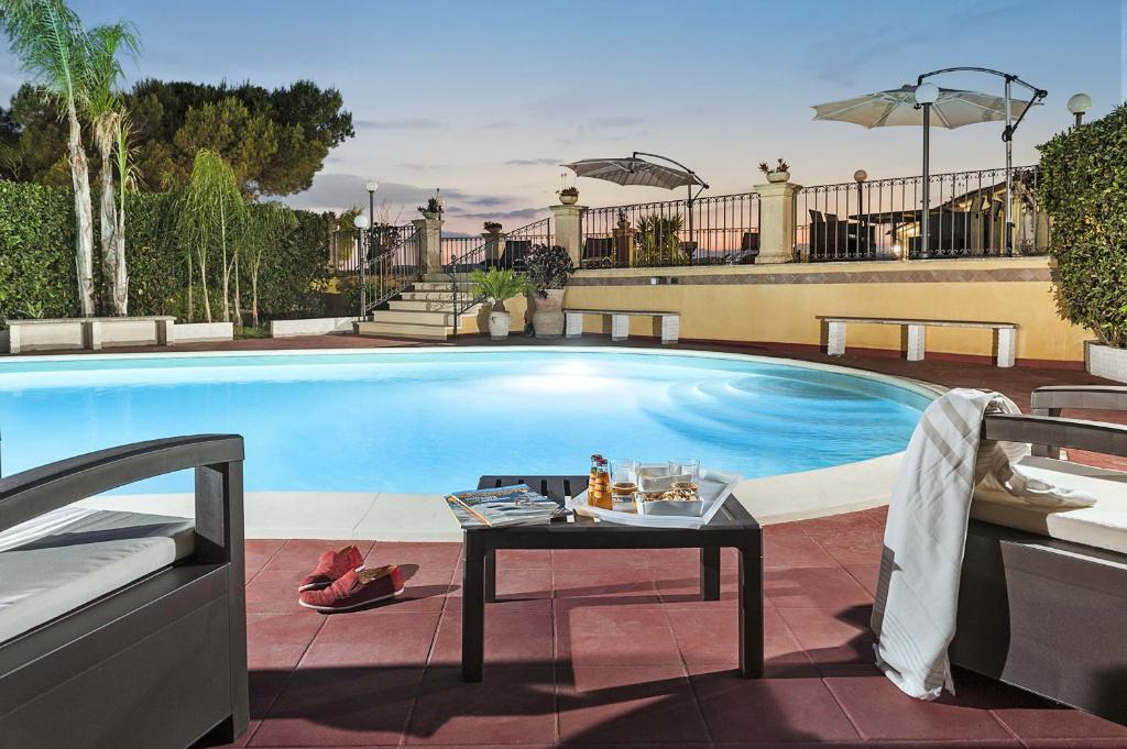 una piscina con una mesa delante en Villa Carolina, en San Corrado di Fuori