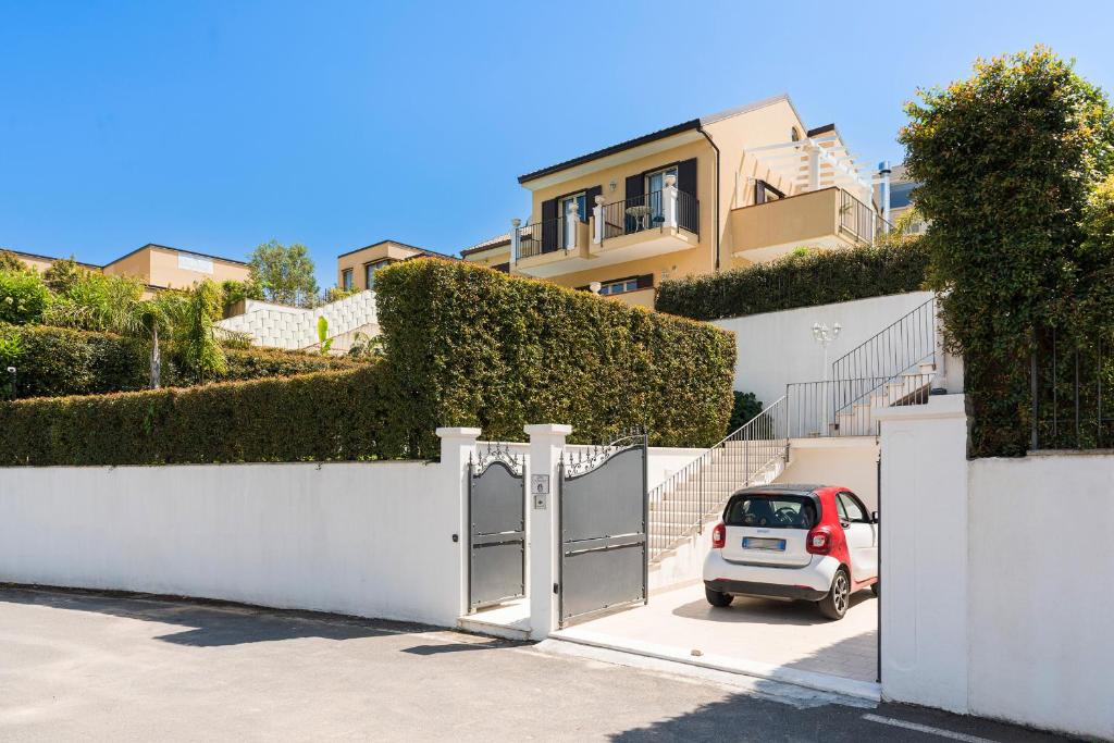 une petite voiture garée dans une allée à côté d'un bâtiment dans l'établissement Villa Giutitta, à Taormine
