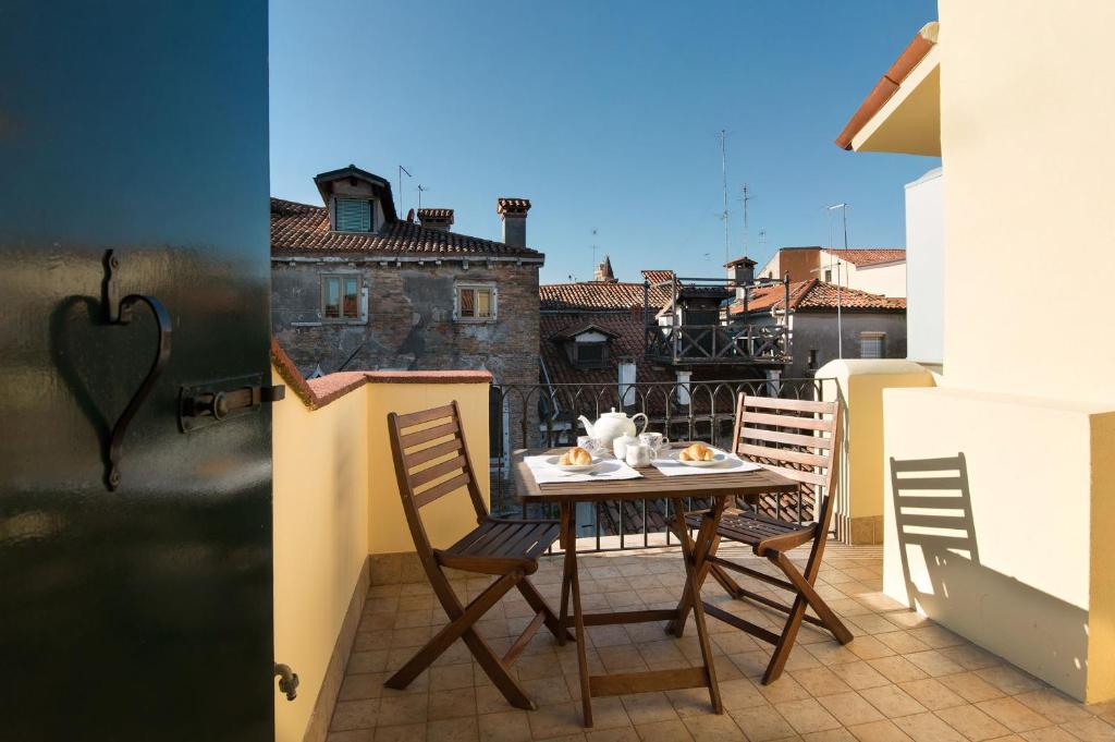 a balcony with a table and chairs on a balcony at Rialto in Venice