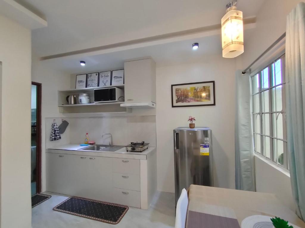 a kitchen with a stainless steel refrigerator and a sink at Gensan Homey Apartment in General Santos