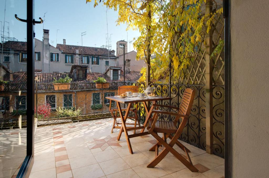 威尼斯的住宿－聖賈科莫度假屋，露台的阳台配有桌椅