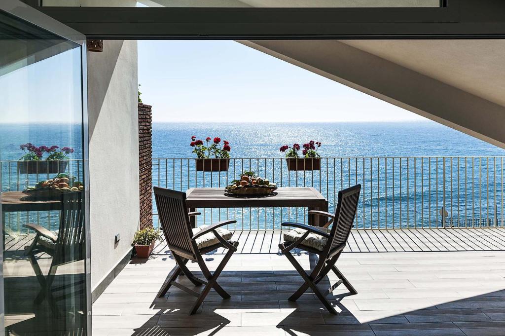 a table and chairs on a balcony with the ocean at Alyssa in Taormina