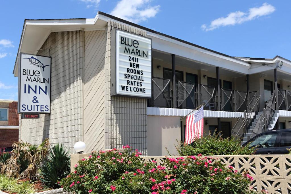a building with signs for the blue man inn and suites at Blue Marlin Motel in Virginia Beach