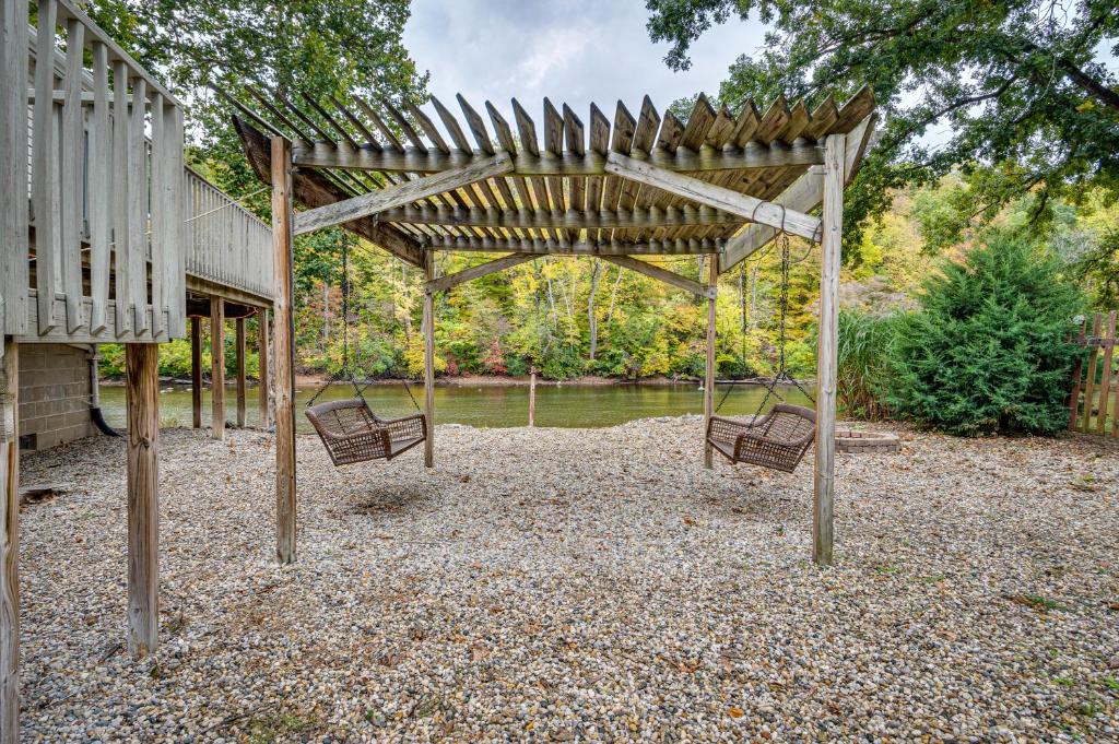two chairs sitting under a wooden pergola at Riverfront Brookston Retreat w/ Deck & River Tubes in Brookston