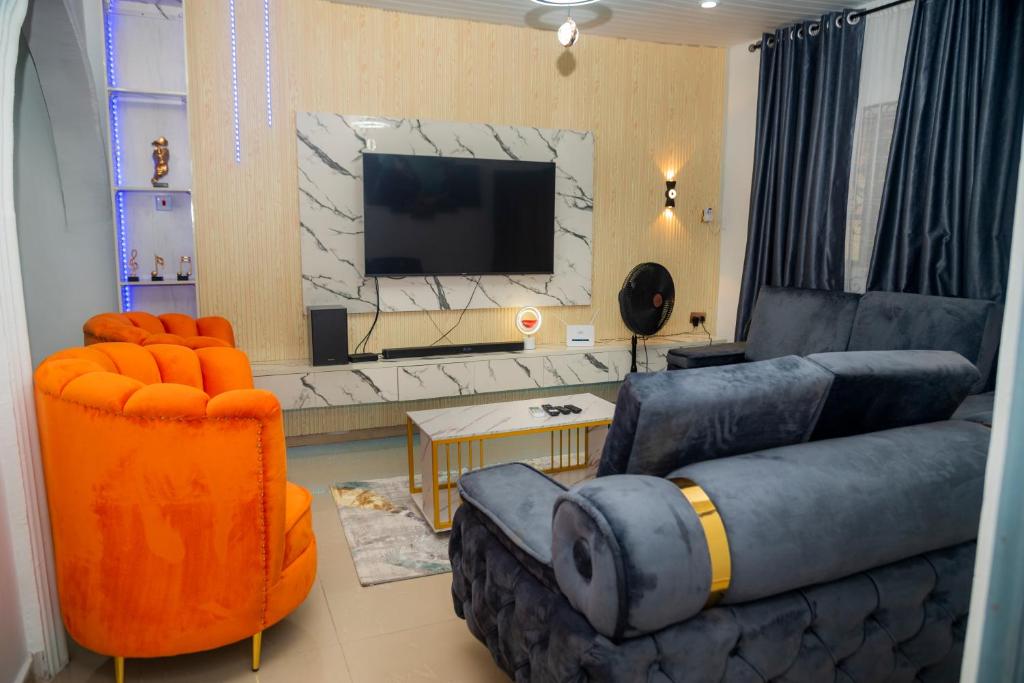 Budget Bliss Suites في بنين سيتي: غرفة معيشة بها أريكة وتلفزيون