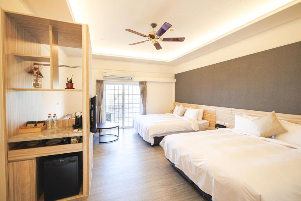 Habitación de hotel con 2 camas y ventilador de techo. en Chill hill cottage en Taiping