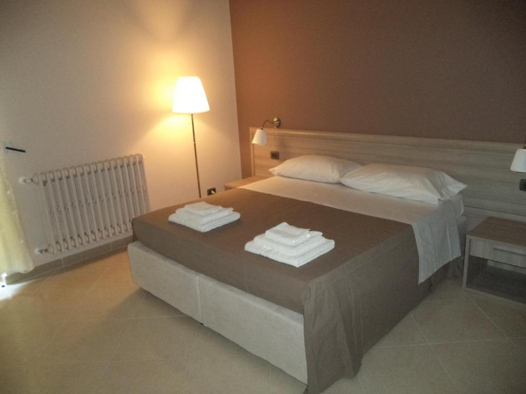 - une chambre avec un lit et des serviettes dans l'établissement B&B SALento, à San Cesario di Lecce
