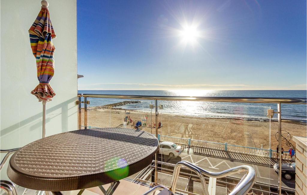 a balcony with a table and a view of the beach at Pet Friendly Apartment In Torrevieja in Torrevieja