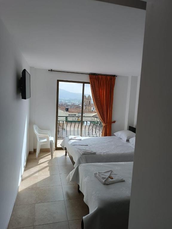 a row of beds in a room with a window at SANTA HELENA HOSPEDERIA in Tibasosa