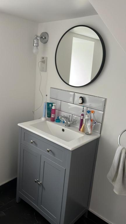 a bathroom with a sink and a mirror at Goncalves place in Bournemouth