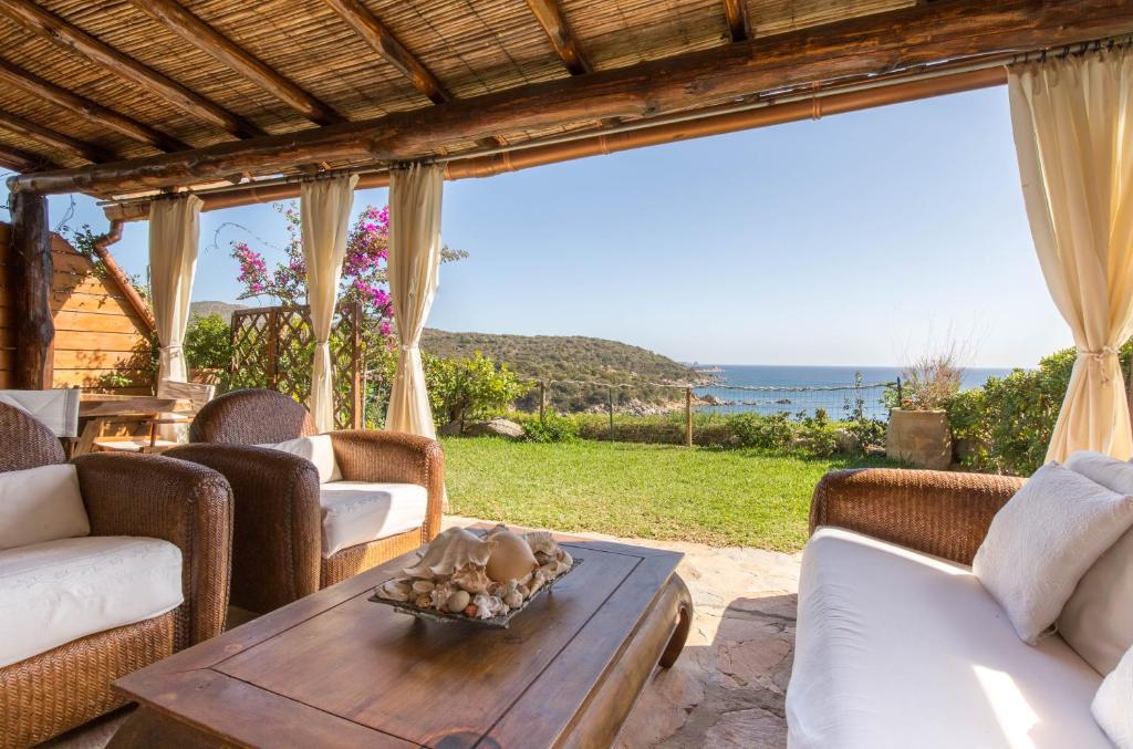 ヴィッラシミーウスにあるLuna Bay Home Retreat con vista sulla baia di Porto Luna a 2 km da Villasimiusのテーブルがあり海が見えるリビングルーム
