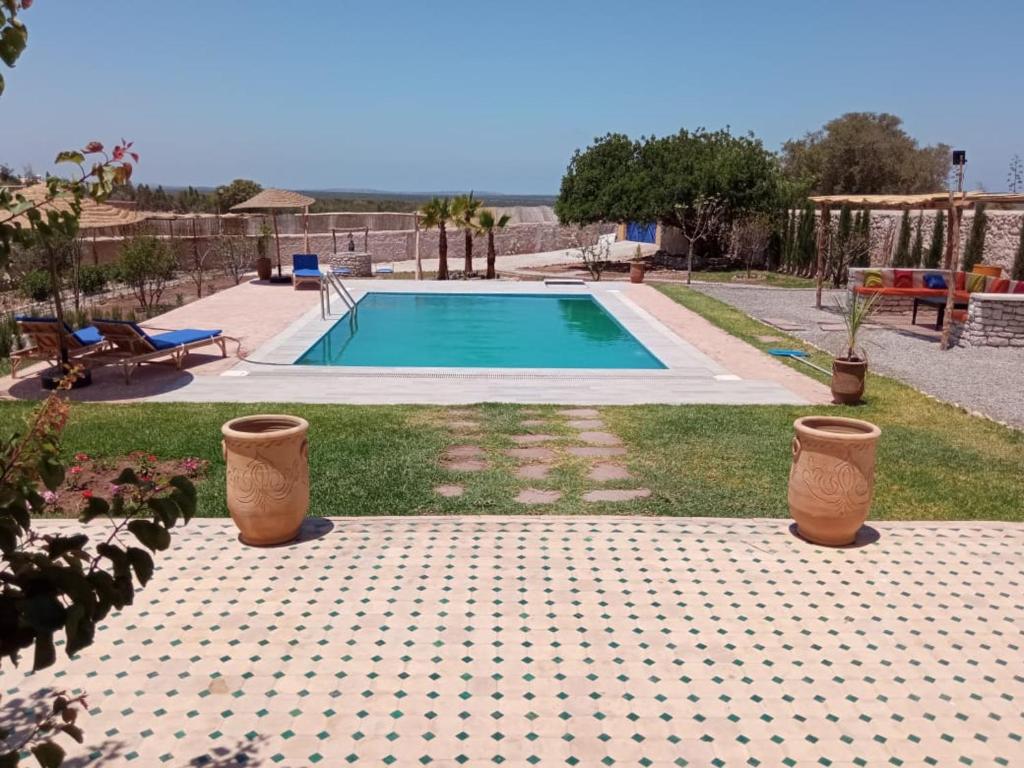 una piscina con due vasi di fronte di Villa DAR MAMA a Essaouira