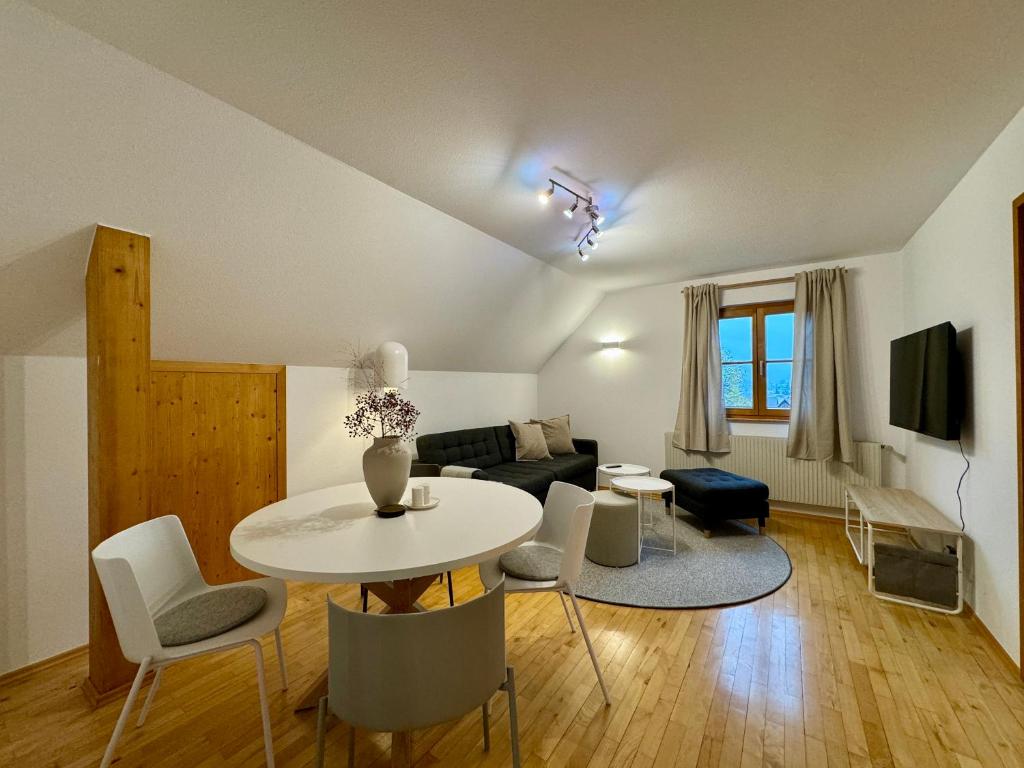 sala de estar con mesa, sillas y sofá en Charmantes Bauernchalet Alois, en Dornbirn