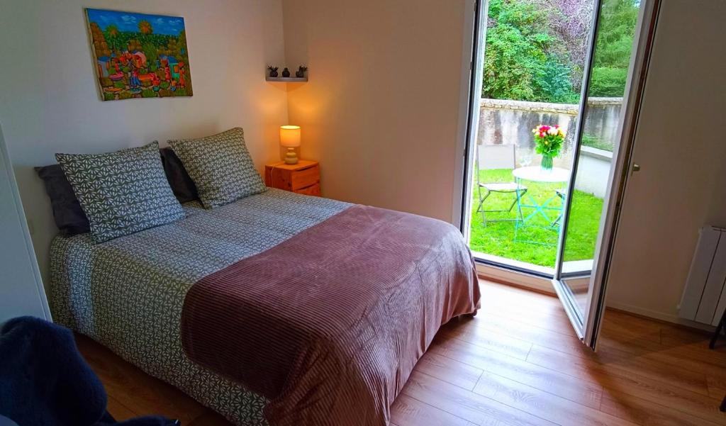 une chambre avec un lit et une porte coulissante en verre dans l'établissement Appartement avec jardin - Centre-ville à 10 minutes à pied, à Caen