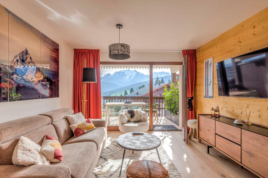 ein Wohnzimmer mit einem Sofa und einem TV in der Unterkunft Stunning flat with views of Mont Blanc in Combloux - Welkeys in Combloux