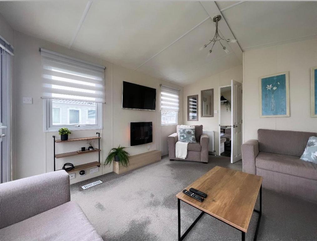 a living room with a couch and a table at At The Waters Edge ( Wansbeck View 26 ) in Newbiggin-by-the-Sea