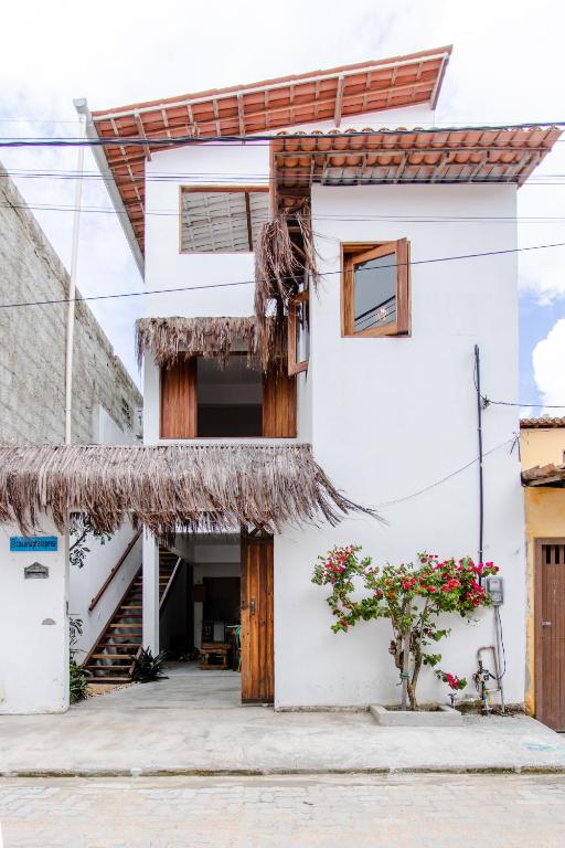 a white house with a straw roof at Casa na Praia Preá - Casa Inteira in Prea