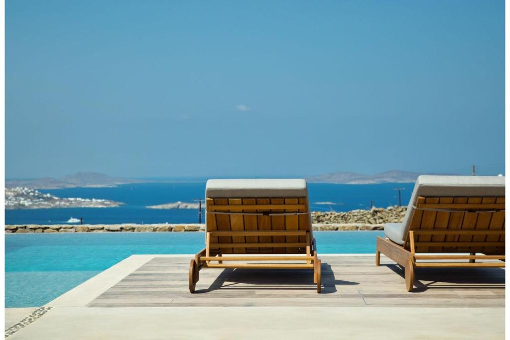 - deux chaises longues installées à côté de la piscine dans l'établissement Super Luxury Mykonos Villa - Villa La Isla Bonita - Private Gym - Private Pool - 5 Bedrooms - Sea Views, à Dexamenes