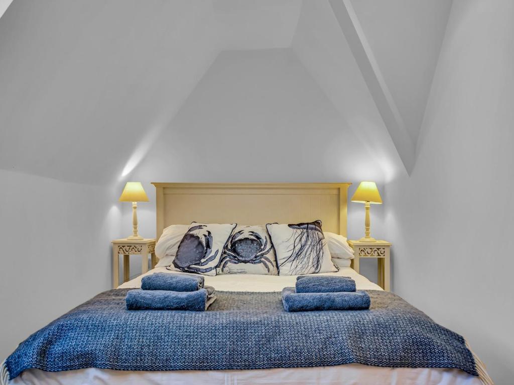 - une chambre avec un lit doté d'oreillers bleus dans l'établissement Pass the Keys Beach Front Home, à Whitstable