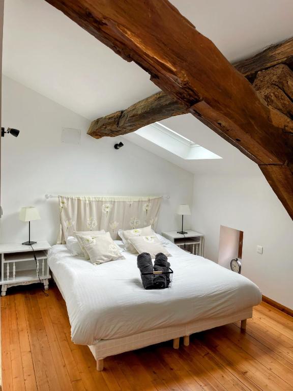 une chambre avec un grand lit blanc avec deux tables dans l'établissement Les Mirabelles, à Tournon-dʼAgenais