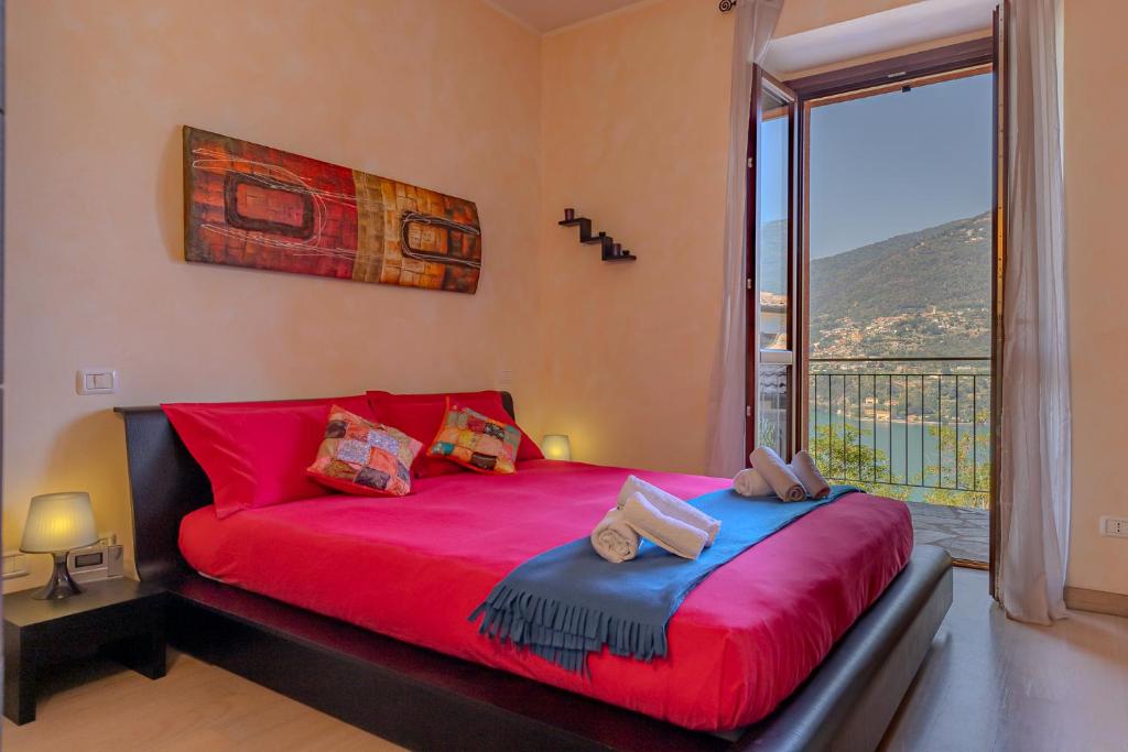 a bedroom with a red bed and a large window at [Como-Blevio] Suite lake view + private garage in Blevio