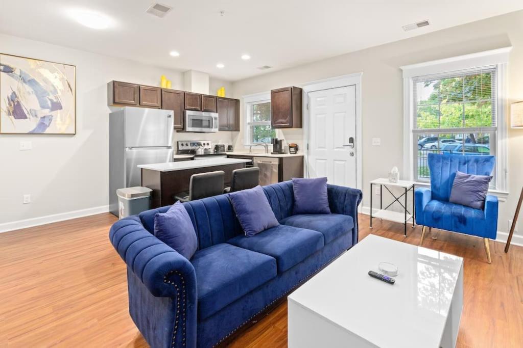 a living room with a blue couch and a kitchen at Affordable 2-BR Heart of Detroit in Detroit