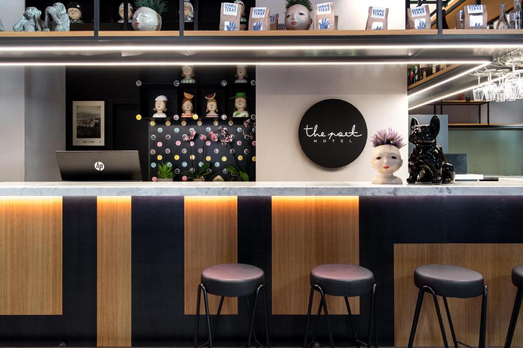 a bar with stools and a laptop on the counter at The Poet Hotel in La Spezia