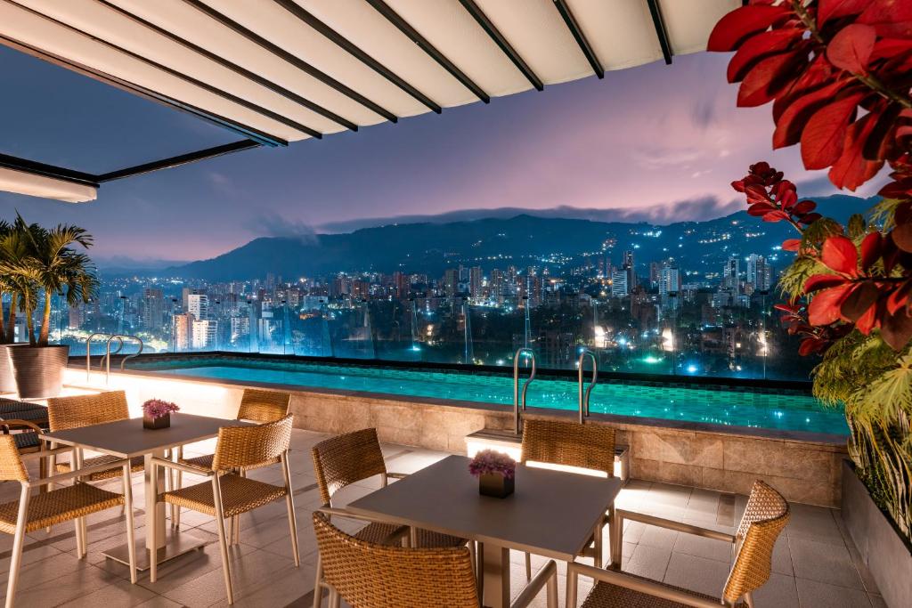 un restaurante con vistas a la ciudad por la noche en Hotel York Luxury Suites Medellin by Preferred en Medellín