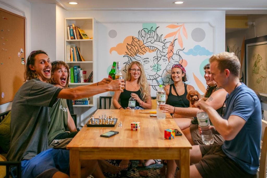 河内Downtown Hostel & Rooftop Bar的一群坐在桌子旁喝着饮料的人